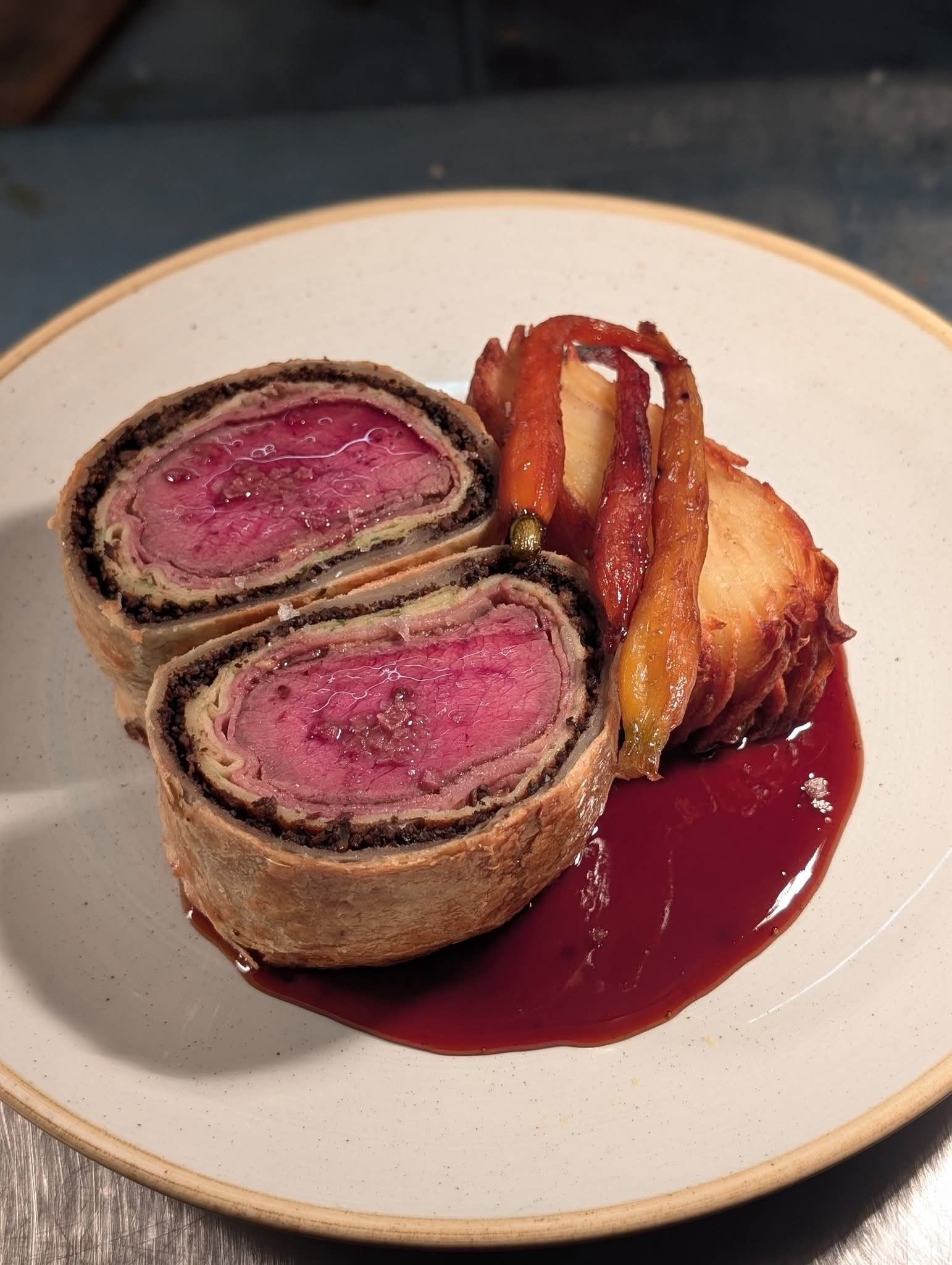 Beef Wellington plated in a premium pub dining setting